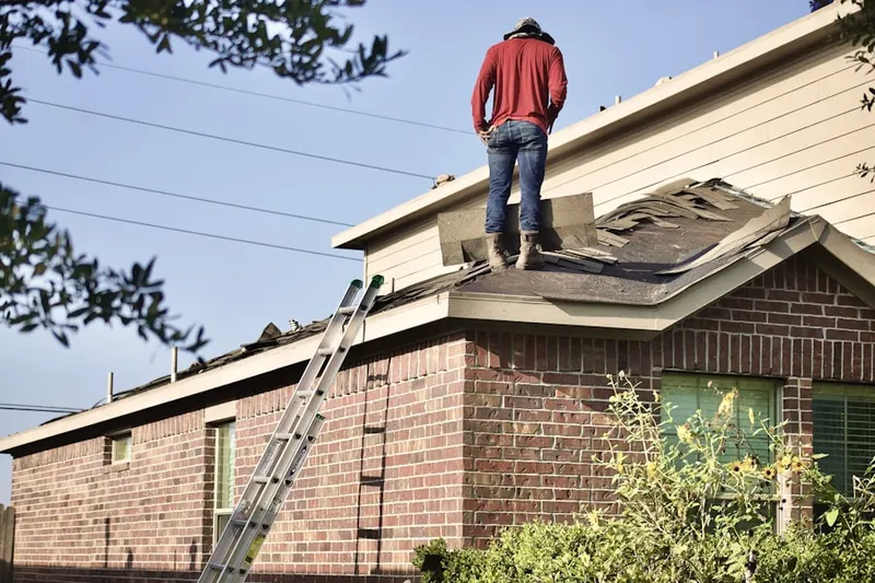 Professional roofer working on a residential roof in Meredith